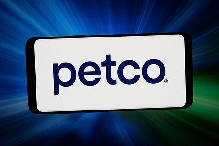 In this photo illustration, the logo of Petco Health and Wellness Company Inc. is displayed on a smartphone in front of abstract background on computer screen.