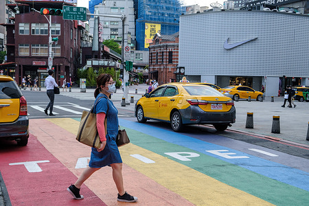 A woman walks in Ximending shopping district while wearing a face mask amid a surge of Covid19 cases. Taiwan Central Epidemic Command Center (CECC) reported a total of 180 new COVID-19 cases and raised the alert level to level 3 in Taipei.