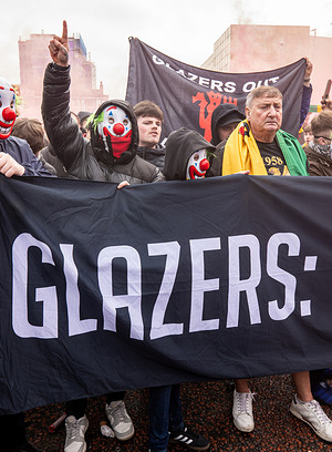 Manchester United supporters wear clown masks during the rally. Manchester United supporters, many wearing clown masks, and letting off flares protested at Old Trafford Manchester United football club. The protest against the club’s ownership. The fans likened the owners under the Glazer family and Sir Jim Ratcliffe to a circus and wore clown masks to indicate this.