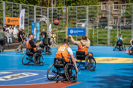 Men seen playing basketball in wheelchairs. Veterans of the Russian-Ukrainian war, players of veteran national teams, and influencers play basketball “GART | Wheelchair Basketball”, on a basketball court in Lviv with the support of the Center for Initiatives “Return Alive” and the Ministry of Veterans, in Lviv. This is an event where anyone who wants can join and try their hand at the game. The event was also attended by skeleton athlete, Olympic flag bearer, Vladyslav Geraskevych, who honored the fallen athletes with his “Helmet of Memory”.
