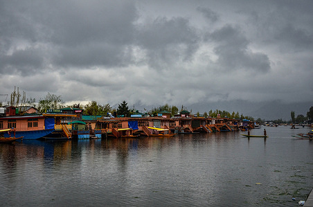 A boatman rows his boat across the Dal lake during rainfall in Srinagar. An orange weather alert is in place in the Kashmir valley until April 6. The weather department said that intermittent rain in plains and snowfall over higher reaches is likely to continue at most places of Jammu and Kashmir in the next 24 hours.