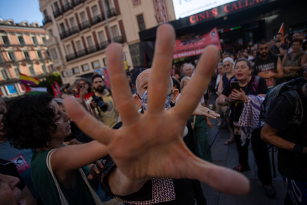 An angry protester blocks the camera lens with a hand during a rally organized by the National Confederation of Labor (CNT) in Madrid’s Plaza de Callao. The demonstration called for the release of the 'Switzerland 6,' union members recently imprisoned on charges of serious coercion and obstruction of justice against the owner of the 'La Suiza' bakery in Gijón. The National Confederation of Labor staged an intervention in defense of a former bakery employee who was alleging workplace and sexual harassment by the owner.