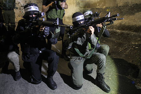 A Palestinian gunman takes part in an armed protest in Jenin refugee camp in the West Bank. The gunmen took part in the show of force to honour the Palestinian leader Bara' al-Lahlouh who was shot dead by the Israeli army during a raid in Jenin.