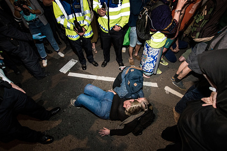 A boy embraces the activist Genevieve Scherer as she stick her hand with glue on the ground to block the passage of the truck that was carrying the boat "Berta Caceres", close to the BBC headquarters during the Extinction Rebellion Strike in London.

Hundreds of policemen were mobilized to remove the pink boat from Oxford Circus. 
Extinction Rebellion have blocked five central London landmarks for fifth day in protest against government inaction on climate change.