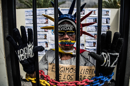 A demonstrator seen protesting behind bars during a protest.
The NGO Foro Penal (Penal Forum), carried out a street activity for the release of political prisoners and demand justice for the people who died during the protests of the year 2014/2017. 
More than 300 people are in prison for protesting against the government of mature nicolas and more than 200 have lost their lives