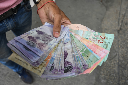 A man seen holding Venezuelan bank notes.
General strikes against the new currency and the economic measures applied by the Government of Venezuela.