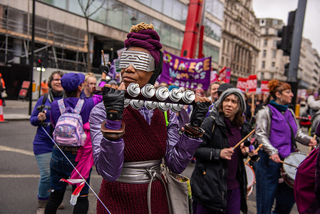 A woman plays an instrument during the 19th Annual Million Women Rise March and Rally! We march in sisterhood, solidarity and unity, to protest the lack of action to address male violence. We march to remember, and grieve, the countless women and girls who have been killed through male violence, including through state inflicted / sanctioned abuse.