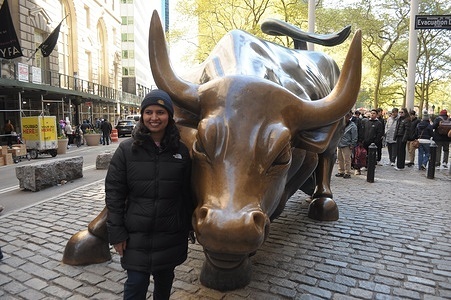 A person takes photos by the "Charging Bull" statue in the Financial District in Manhattan, New York City.