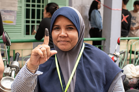 A Cham woman (Cambodian muslim community) shows her tinted index finger after casting her vote in a polling station located in a mosque's grounds during the country's sixth general election.
Cambodia voted on July 29 in an election set to extend strongman premier Hun Sen's 33 years in power after the only credible opposition was dissolved, effectively turning the country into a one-party state.