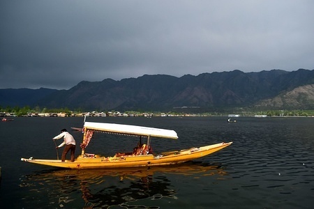 A boatman rows his boat on a cloudy day at Dal lake in Srinagar, Indian administered Kashmir. 
The Kashmir Valley would remain mostly cloudy on Sunday, with scattered rain and thundershowers across the state for the next two to three days, a local Meteorological Department forecast said.