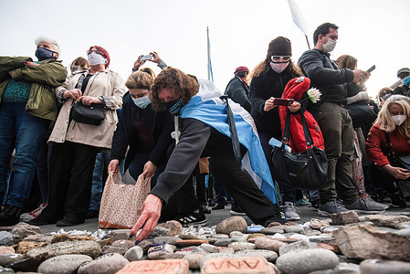 Two women leave stones with the names of their family members who died due to the coronavirus.March of the stones, a tribute to the victims of Covid-19 and repudiation of the government. The call seeks to represent with a rock each one of the deceased by coronavirus and expose it in front of the central government buildings, in repudiation of the management of the pandemic in Buenos Aires, Argentina.
