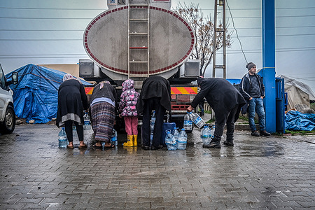 People are seen fetching water from a water tanker in a tented city for people made homeless by the earthquake. The southeastern city of kahramanmaras was one of the closest to the epicenter the february 6th earthquake which struck southern and central turkey and northern and western syria. some 1000 buildings reportedly collapsed in the city. tents and temporary shelters have been erected for those made homeless by the disaster.