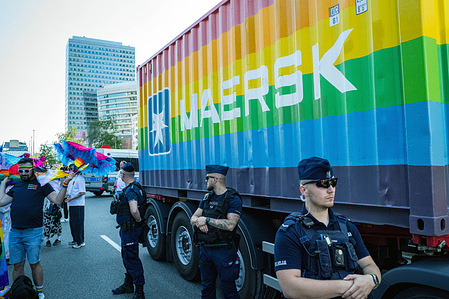 Police guard the Maersk truck before the Pride parade begins. On the afternoon of the 14th of June, pro-Palestine anti-genocide protesters block the annual Pride celebration parade through Warsaw, Poland. The protesters believe the parade has become increasingly commercialised in recent years, a trend that reached its zenith in 2025 with the inclusion of shipping company Maersk. The Danish logistics firm is known to ship weapons to Israel, weapons that are used in the genocide in Gaza. The protesters believe that Maersk is using the annual Pride parade to "pinkwash" their reputation and distract from their involvement with Israel. Demonstrators blocked the progress of the Maersk group, threw blood-red paint at the truck, and some climbed atop the vehicle with a loudhailer and a Palestine flag. Protesters chanted the slogan "Maersk, Maersk, you can't hide; you can't pinkwash genocide".