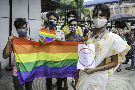 Transgender people from LGBTQ community hold an LGBTQ Pride flag and "Vaccinated with Pride" printed placard after being vaccinated.
50 Members of LGBTQ community in Kolkata got their first dose of Covishield vaccine from a vaccination centre organized by activists of Techno India and Pranta Katha.