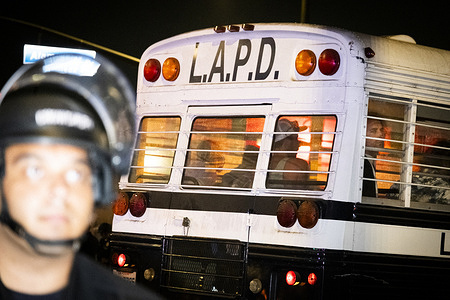 A police officer stands in front of a Los Angeles Police Department bus during the demonstration. U.S. Immigration and Customs Enforcement (I.C.E.), Get Out Of Los Angeles protest in Downtown Los Angeles, where protestors gather to demand that I.C.E. agents stop detaining and arresting migrants.
