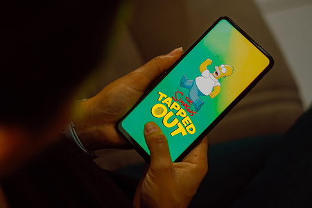 In this photo illustration, the Simpsons: Tapped Out logo is displayed on a smartphone screen.