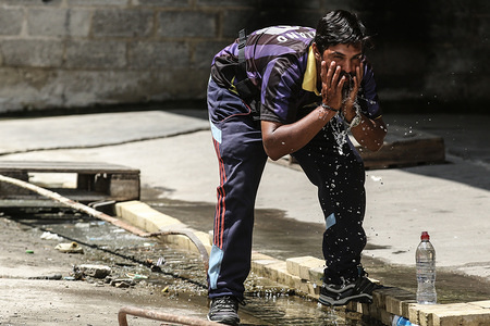 A migrant seen washing his face inside the disused Ladopoulos paper factory, which has been turned into a makeshift camp next to Patras port where migrants regularly attempt to stowaway on vehicles traveling to Italy.
