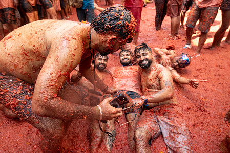 People pose with crushed tomatoes. During the 78th annual "La Tomatina" festival, the event organizers have confirmed the launch of 120 tons of tomatoes distributed in six trucks.