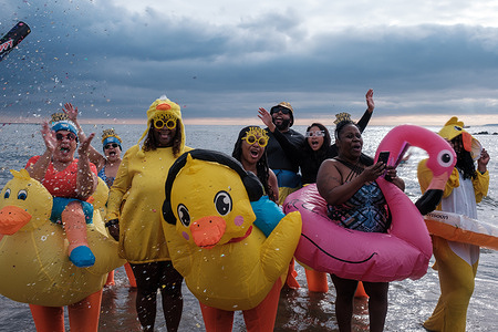 Participants dressed as ducks and a flamingo cheer as confetti is popped. New Yorkers celebrate the New year with the annual Coney Island Polar Bear Plunge. The event raises money for various charities.