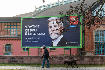 A man with a dog walks past an election billboard for presidential candidate Petr Pavel, a former military general, placed on the street of Olomouc. The first round of presidential elections in the Czech Republic will be held on the 13th and 14th of January, 2023. As per current election surveys, candidates with the highest chance to make it to the second round of elections are Petr Pavel, Danuse Nerudova and former prime minister Andrej Babis.