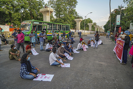 Bangladeshi students with placards sit in the middle of the street during the demonstration.
Bangladeshi student protest against digital security act, police also arrested a young university lecturer Sirajum Munira after she posted a comment on Facebook mocking the death of the country's former health minister from Coronavirus, police said.