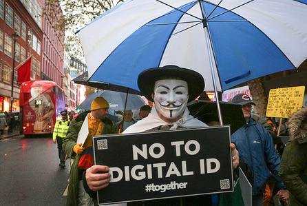 A protester wearing an anonymous mask marches along Charing Cross Road carrying a ’No To Digital ID’ placard during the demonstration. The Mass Non Compliance group are protesting against the Labour Government's plan to introduce digital identity cards, claiming that it would increase the government's surveillance powers while threatening individual privacy and freedom.