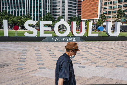 A man wearing protective mask walks in front of "I Seoul U" board at Seoul city hall.
50 new coronavirus cases were confirmed by Korea Centres for Disease Control (KCDC) on 9 July during the Second Wave of the virus.