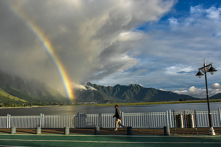 A commuter walks along the road as a rainbow appears after heavy rainfall triggered flash floods and landslides in Jammu and Kashmir. Jammu and Kashmir residents took a breath of some relief as they witnessed sunshine following three days of continuous heavy rainfall across the state. The Jammu-Srinagar national highway was closed for traffic for the third consecutive day due to multiple landslides triggered by heavy rains. The death toll in the rain-ravaged Jammu and Kashmir rose to 41.