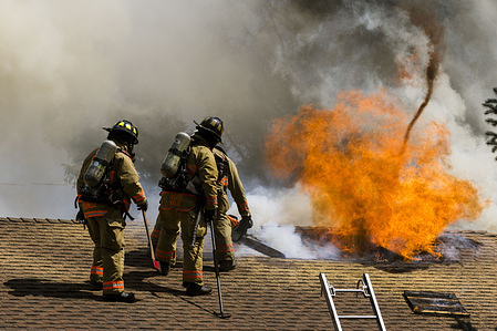 Firefighters work to open the roof of a burning house.
Firefighters worked to put out and attic fire in a single family home. The cause is still under investigation.