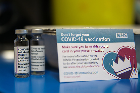 Vials containing Oxford/AstraZeneca vaccine and Covid-19 vaccination record card seen at a vaccination centre in London.