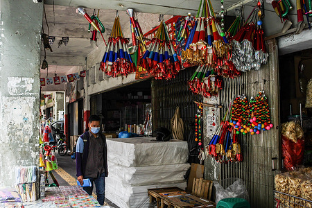 A man wearing a face mask as preventive measure against COVID-19 walks past a trumpet shop in Bandung. 
The Bandung City Government plans to close a number of main roads from afternoon to the morning and conduct checks on people who will be entering Bandung City on New Year's Eve as a preventative measure against the spread of COVID-19. Currently Indonesia has recorded over 700.000 cases of COVID-19.