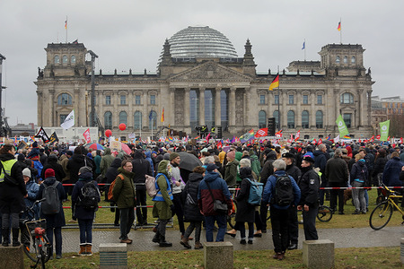 A group of protestors gather in front of the Bundestag during the demonstration. A political protest took place in Berlin with over 100,000 people attended. A human chain was organized at the federal building by the Hand in Hand - #WirSindDieBrandmauer as a symbol of their support for democracy solidarity against right-wing developments in Germany.