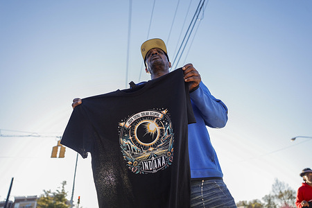 A vendor sells Indiana solar eclipse t-shirts at the corner of North Walnut and 17th Street in Bloomington. With thousands expected to flock to Bloomington, situated in the path of the 2024 total solar eclipse scheduled for Monday, April 8, the T-shirt vendor has announced his presence at the same location starting from 7 a.m. on Monday, continuing through the entire weekend.