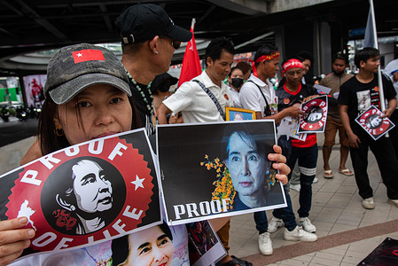 A Myanmar migrant group member holds portraits of Aung San Suu Kyi during the protest to mark the international labor day in Bangkok. Myanmar migrant group held a demonstration in Bangkok to mark the International Labor Day and calling for the workers rights against the Myanmar military government.