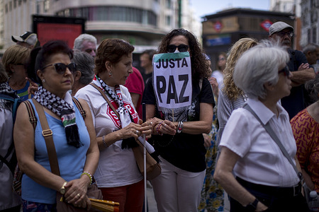 Protesters with Palestinian scarves seen during a rally calling for an end to Israeli attacks on Palestine, organized by the "Stop the War" platform under the slogan "For peace. End genocide," in Madrid's Callao Square.