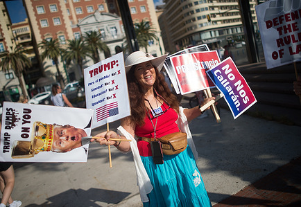 A protester is seen holding placards as she takes part in a protest against Trump government, organized by 'Democrats abroad', at La Marina square. Americans living in Spain have organized several protests against the Trump administration. 'Democrats abroad', formed by US citizens living outside the United States, is the official organization of expats from Democratic Party.