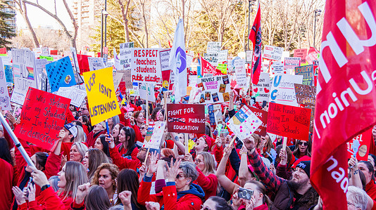Protesters hold placards expressing their opinion during the demonstration. Over 20,000 people gathered outside the Alberta Legislature to protest the state of education under Premier Danielle Smith as the Throne Speech was read. The demonstrators, including striking teachers and their supporters, held signs calling for smaller class sizes, more educational assistant support, and fair wages. Teachers have been on strike since October 7 and have already rejected two offers from the province, while their latest proposal has yet to receive a response. The provincial government is expected to introduce back-to-work legislation on Monday.