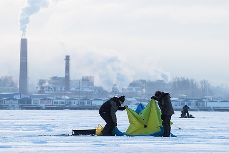 People fish in the ice-covered Gulf of Finland near Neva Guba area.