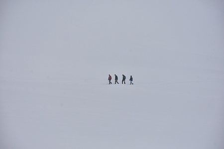 Visitors walk through the snow covered field during snowfall in Gulmarg, a world famous ski-resort, about 55kms from Srinagar, the summer capital of Jammu and Kashmir.