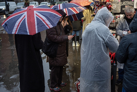 Tourists buy Union Jack designed umbrellas on Westminster Bridge. The country experienced unsettled wet and windy weather over the last few weeks. It was characterized by a series of low-pressure systems bringing spells of rain and strong winds from the Atlantic.