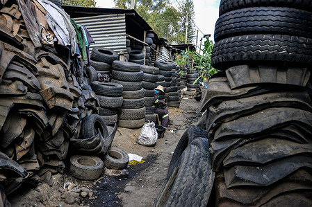 An artisan makes hand-crafted tire sandals from used tires at a street workshop in Nakuru Town. Approximately 280 million used tires are discarded each year, and only about 30 million of these are retreaded or reused. If not properly managed used tires end up polluting the environment. By repurposing them, artisans in Nakuru and other places are helping keep the waste from getting into the environment.