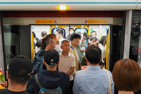 People take on a MTR subway train at Admiralty station in Hong Kong.