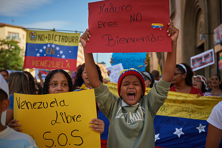 A kid chants slogans while holding a placard expressing his opinion during the demonstration. Protesters and Venezuelan citizens have gathered in the streets of Pamplona, to raise their voices against the electoral fraud that occurred in the elections held on July 28 in Venezuela, thus denouncing a chain of events after the elections, 24 murders of young people and the imprisonment of more than 1,300 people for their active participation in the voting process or as witnesses at polling stations.