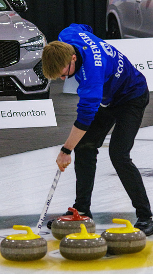 Scotland's Ethan Brewster brushes their last rock in the button to finish the 8th end in the Bronze Medal match against Denmark at the World Curling Junior Mixed Doubles Championships. Scotland 10 -7 Denmark