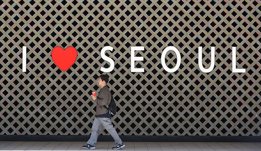 A person passes through a place where Seoul is written in English letters on a wall near the Seoul train station in Seoul,
