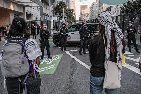 Riot police block the protestors from nearing the Moscone Center. The Asia-Pacific Economic Cooperation (APEC) is hosting its 2023 summit in San Francisco, California, from November 11 to November 17, primarily centered at the Moscone Center. The summit attracts leaders and business representatives from various nations, engaging in discussions on diverse global issues. However, on November 12, a substantial protest unfolds on the streets of San Francisco, drawing thousands of demonstrators from various groups, including those advocating for climate change and pro-Palestine causes. The protestors march from the Ferry Building to the Moscone Center in the afternoon, brandishing flags, placards, and banners. As they approach the Moscone Center, riot police from the San Francisco Police Department (SFPD) intervene, preventing the protestors from nearing the venue.