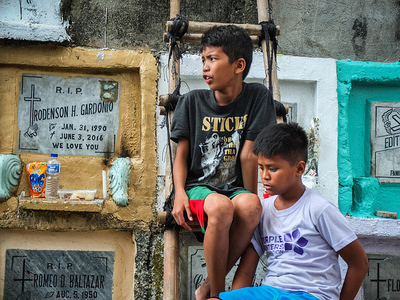 Young boys waiting for clients, their business was to light candles, putting flowers, or to help their client to cross from the other side of the cemetery premises by the use of their bamboo ladder.
Millions of Filipinos flock to cemeteries across the country to visit their departed love ones. Paying their respects to loved ones who have died. It's Filipino tradition and culture.