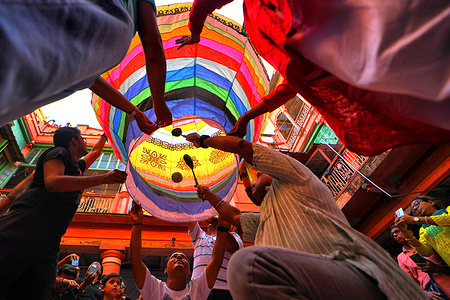 A group of people seen holding a paper lantern during the celebration of the Diwali festival. The Fanush, a paper-made hot air balloon, is an integral part of North Calcutta Heritage Culture, and it is an old tradition to fly Fanush on the day of Kalipujo before Diwali in Kolkata.