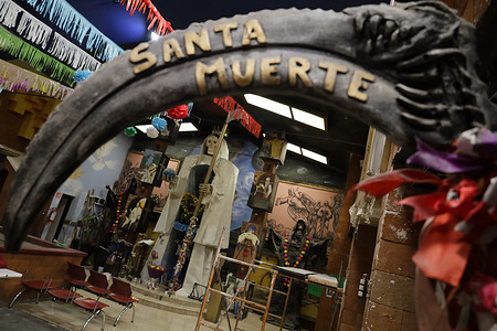 A view inside the temple of Santa Muerte and the Black Angel (The Devil) where people gather to give thanks for favors received on the eve of Holy Week. According to popular belief, Santa Muerte is considered among the "dulia (tribute to angels and saints) as an intercessor and mediator between the earthly and the divine, life and death, heaven and earth." Meanwhile, the Black Angel (The Devil) is one of the representations of Lucifer. Both cults are condemned by the Catholic Church and other religious denominations.