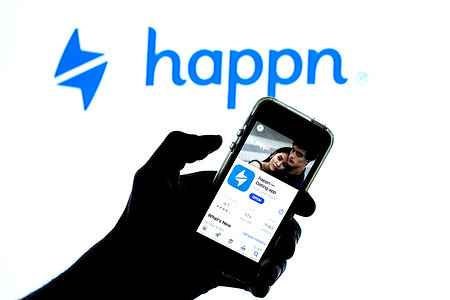 In this photo illustration, the Happn app in the App Store seen displayed on a smartphone screen and a Happn logo in the background.